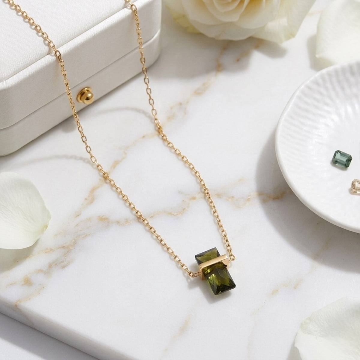 BEHI MILANO Glinka Necklace — green rectangular zircon necklace on white marble dish