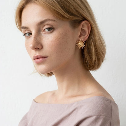 BEHI MILANO Glow Earrings — short blonde model wearing gold sun statement stud in side profile