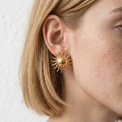 BEHI MILANO Glow Earrings — close-up of model ear wearing 18k gold solar ray statement stud