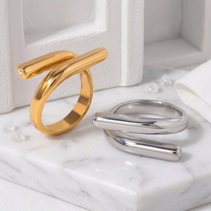 BEHI MILANO Greta Ring — gold and silver sculptural wrap statement rings on white marble