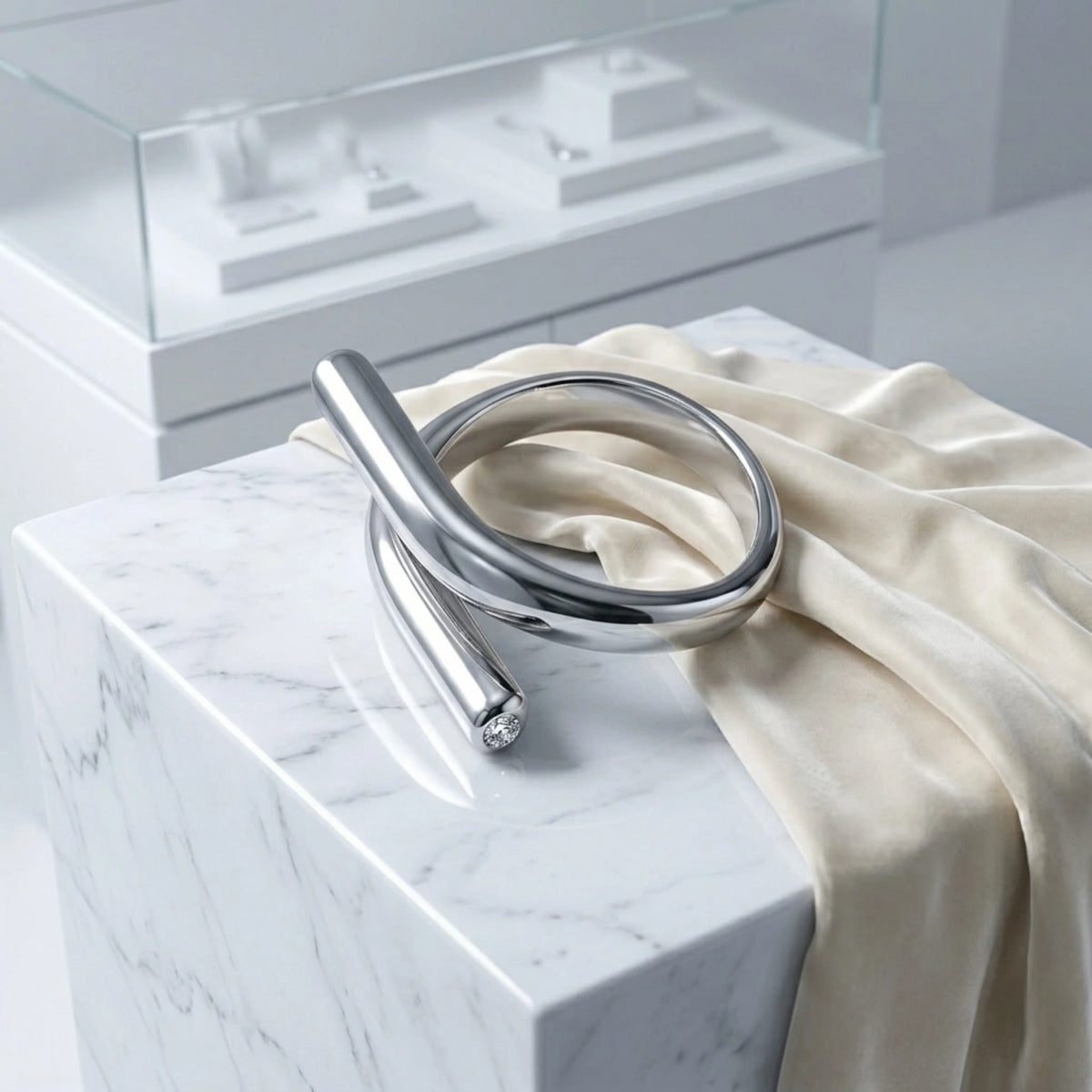 BEHI MILANO Greta Ring — silver crossover ring on marble surface with silk ribbon