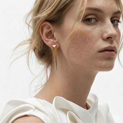 BEHI MILANO Hanika Earrings — blonde model wearing gold tapered geometric statement studs