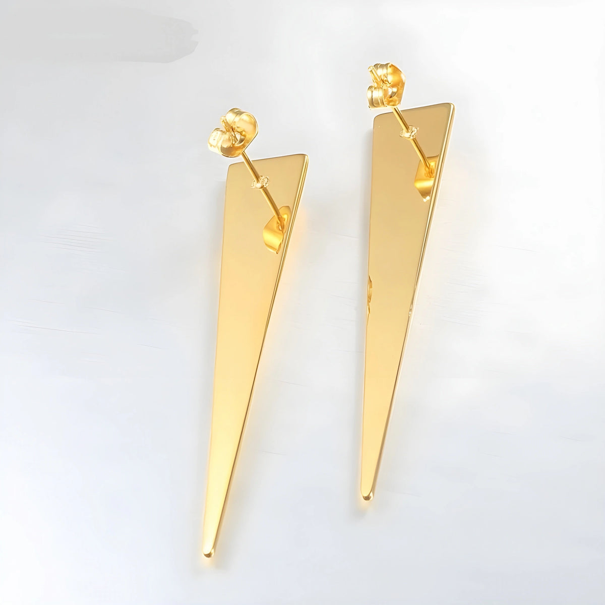 BEHI MILANO Hanika Earrings — pair of 18k gold elongated pyramid studs standing on white background