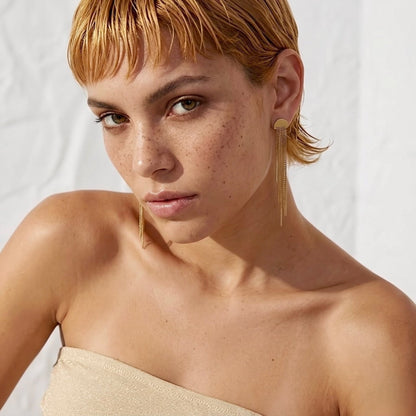 BEHI MILANO Heyley Earrings — short auburn haired model wearing gold cascading tassel drop earrings