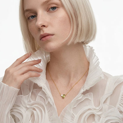 BEHI MILANO Ilona Necklace — blonde model wearing 18k gold green zircon pendant necklace