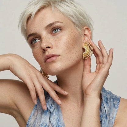 BEHI MILANO Indigamond Earrings — platinum blonde crop haired model wearing gold sunburst fan statement earrings