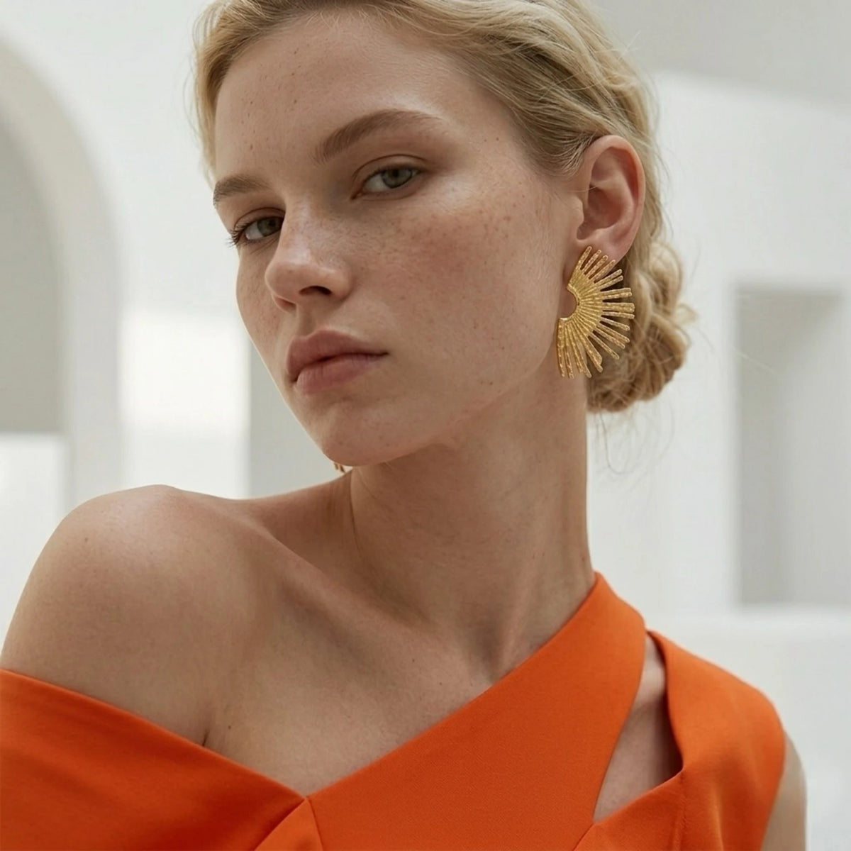 BEHI MILANO Indigo Earrings — portrait of model wearing 18k gold textured fan statement studs