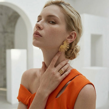 BEHI MILANO Indigo Earrings — side angle view of model wearing gold sunburst fan studs