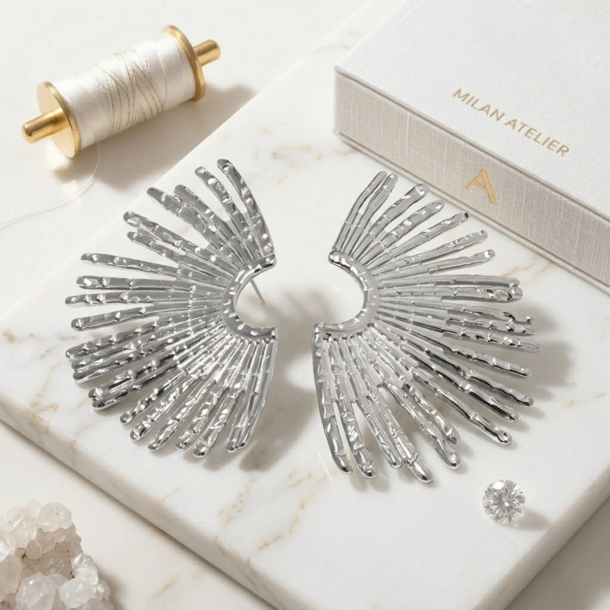 BEHI MILANO Indigo Earrings — silver fan statement earrings displayed on white marble background