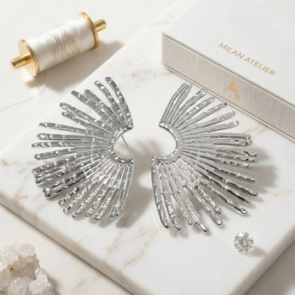 BEHI MILANO Indigo Earrings — silver fan statement earrings displayed on white marble background