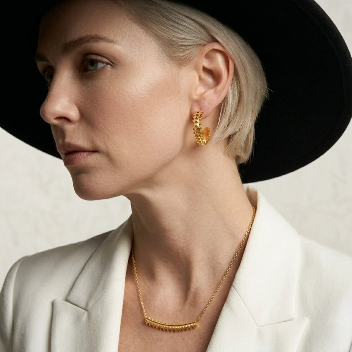 BEHI MILANO Isla Earrings — model wearing 18k gold textured hoops and matching statement necklace