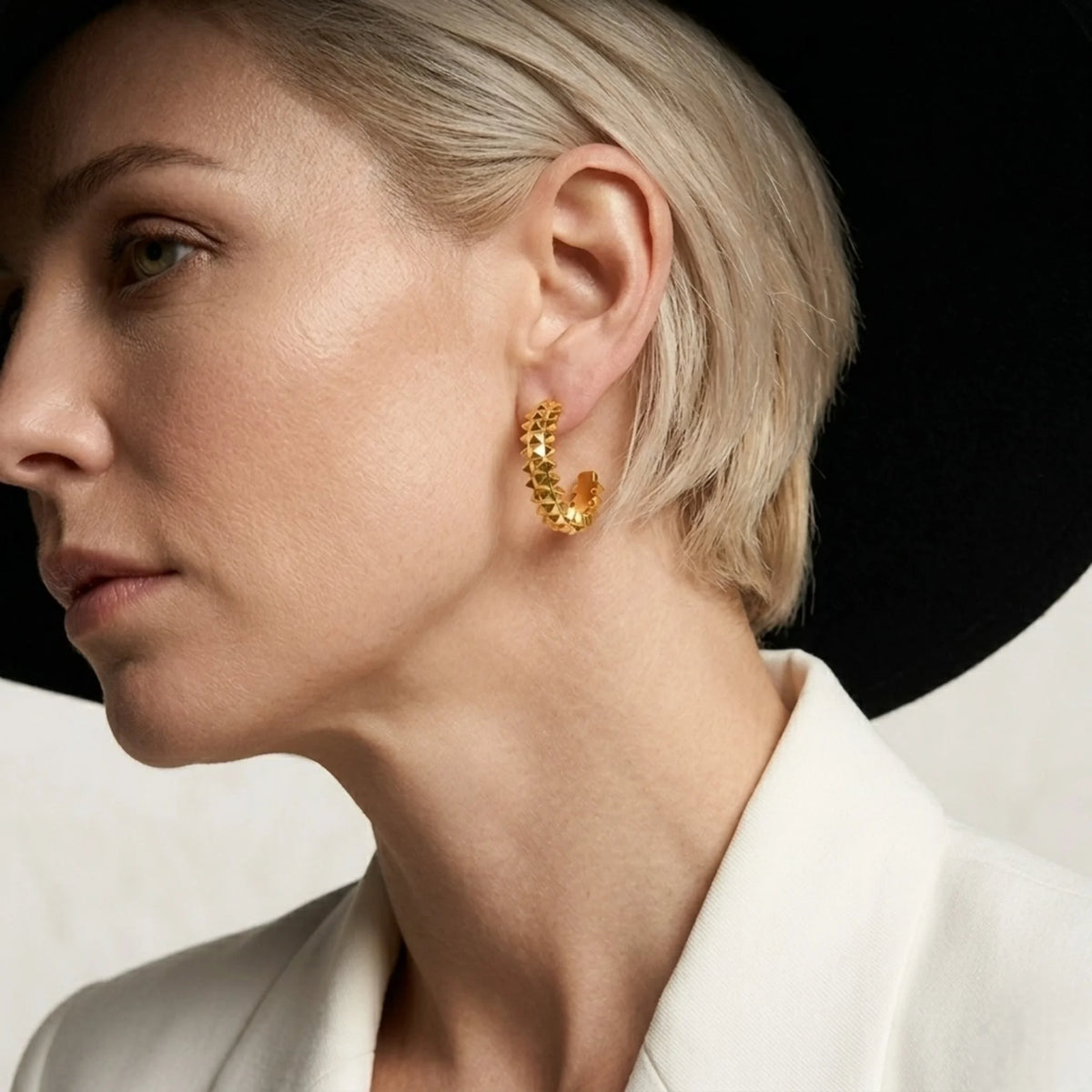 BEHI MILANO Isla Earrings — side profile view of model wearing gold pyramid open hoop earrings