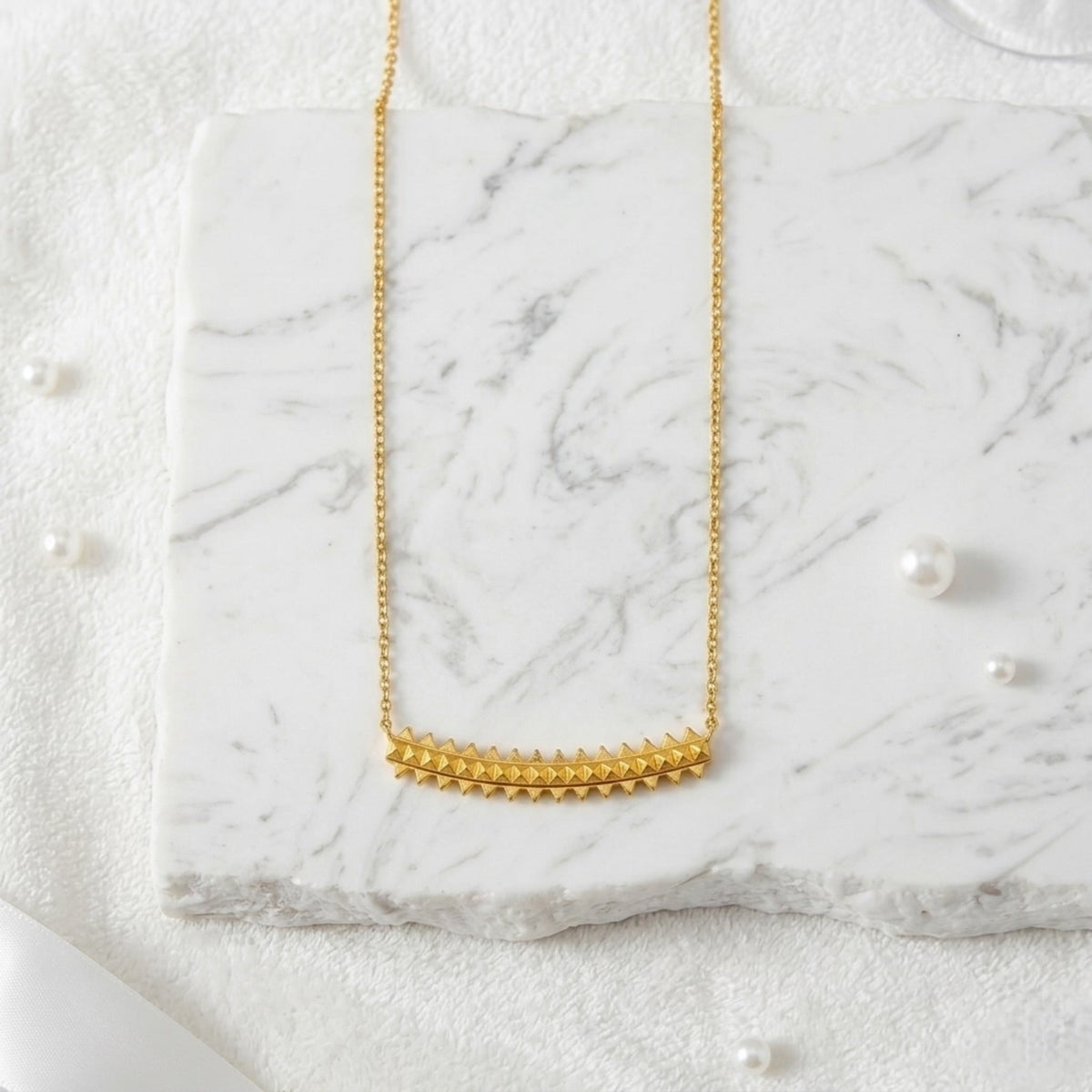 BEHI MILANO Isla Necklace — vertical layout of 18k gold pyramid pendant on white marble backdrop