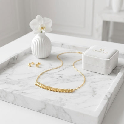 BEHI MILANO Isla Necklace — 18k gold bar pendant necklace resting on marble tray