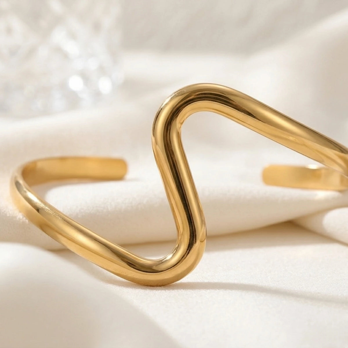 BEHI MILANO Jojo Bracelet — 18k gold serpentine cuff laying flat on white silk