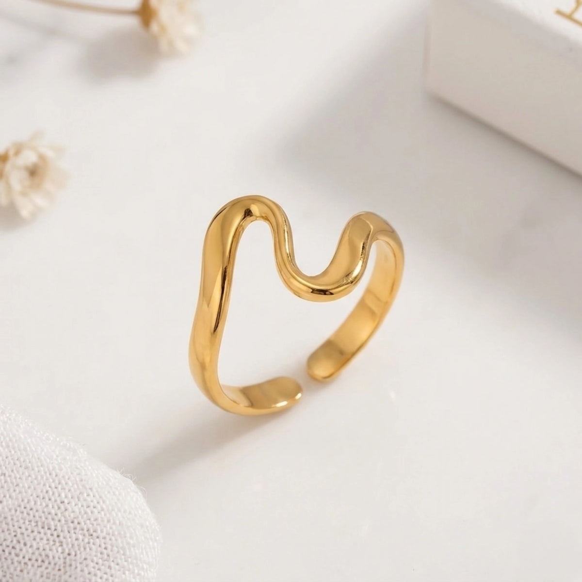 BEHI MILANO Jojo Ring — gold S-wave ring standing vertically on soft white background