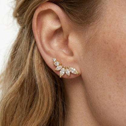 BEHI MILANO Josa Earrings — close up detail of gold crystal petal studs worn on earlobe