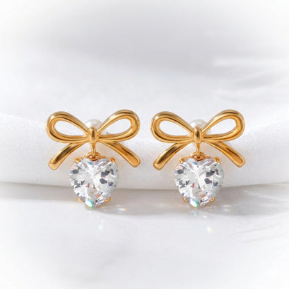 BEHI MILANO Juliette Earrings — gold bow heart crystal earrings on white display with ribbon