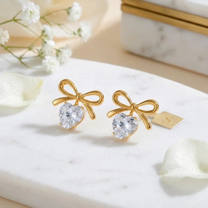 BEHI MILANO Juliette Earrings — 18k gold bow heart crystal drop earrings with white floral backdrop