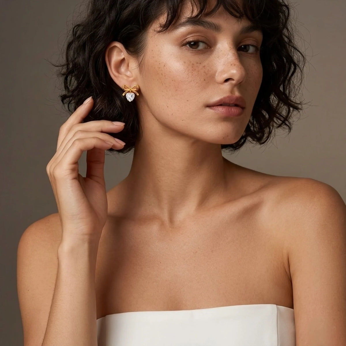 BEHI MILANO Juliette Earrings — model wearing gold ribbon bow heart crystal drop earrings