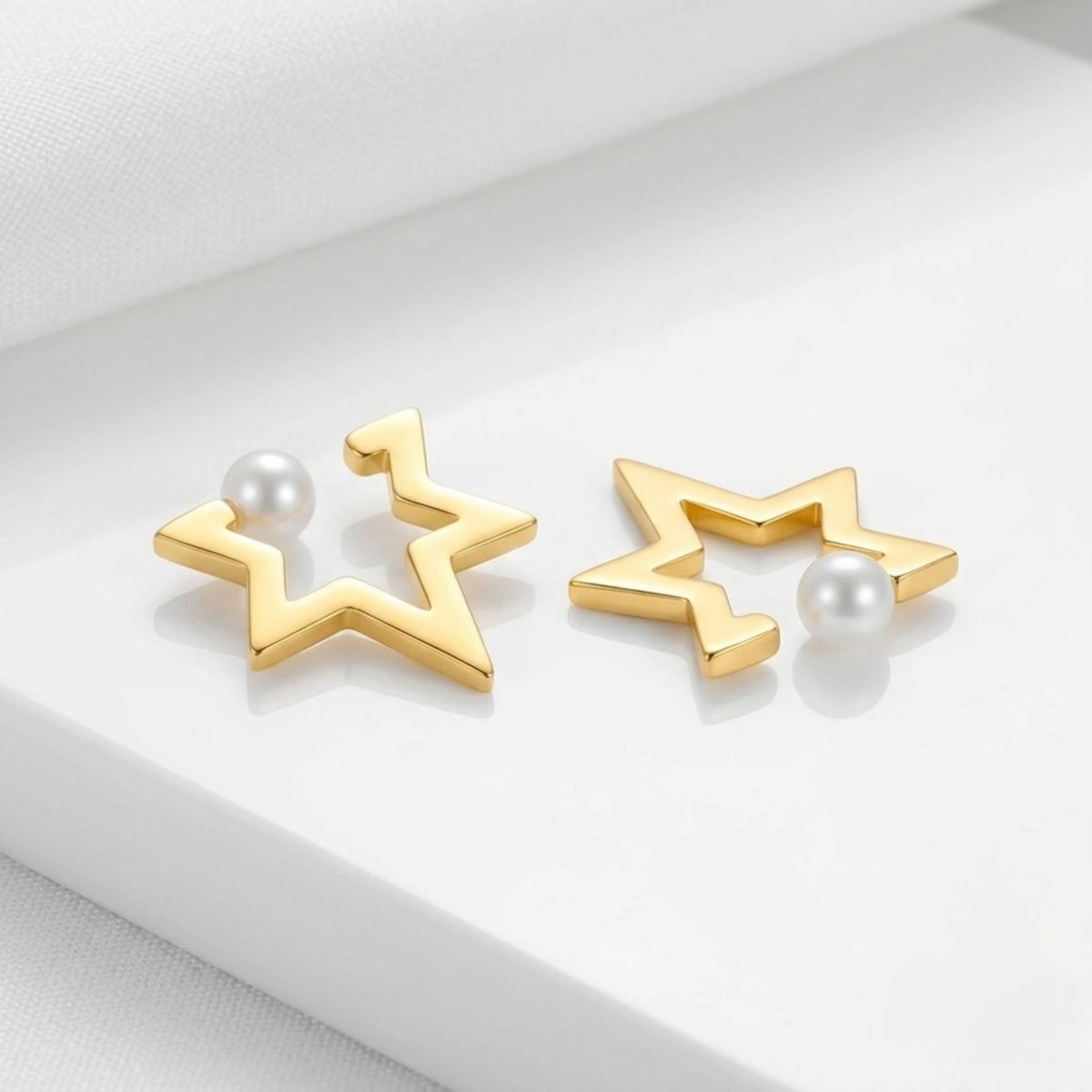 BEHI MILANO Kaia Earrings — side angle of 18k gold star pearl earrings on display stand