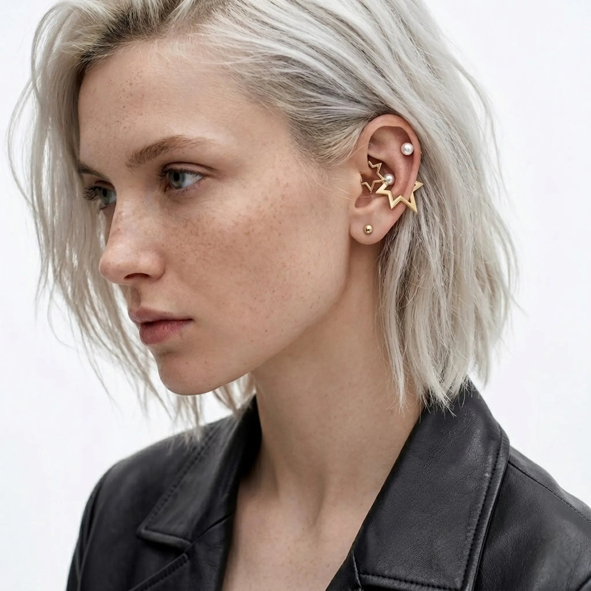 BEHI MILANO Kaia Earrings — close up of platinum blonde model displaying gold star pearl stud on ear