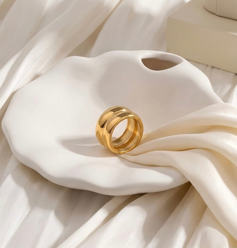 BEHI MILANO Katrina Ring — gold double dome band ring resting inside an organic white ceramic shell dish