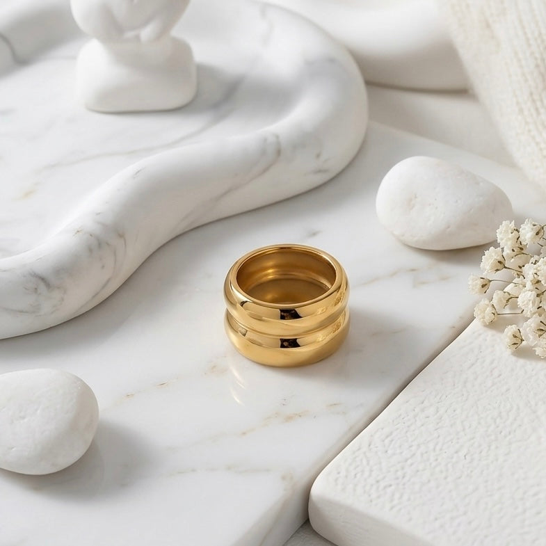 BEHI MILANO Katrina Ring — gold statement ring displayed on white pedestal platform