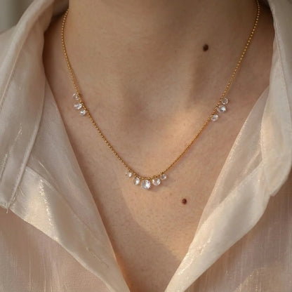 BEHI MILANO Larissa Necklace — close-up detail of gold crystal cascade chain on model's neckline
