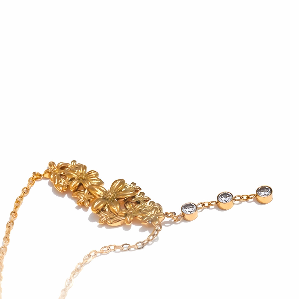 BEHI MILANO Lauris Necklace — curved chain view highlighting gold floral cluster and zircon drop