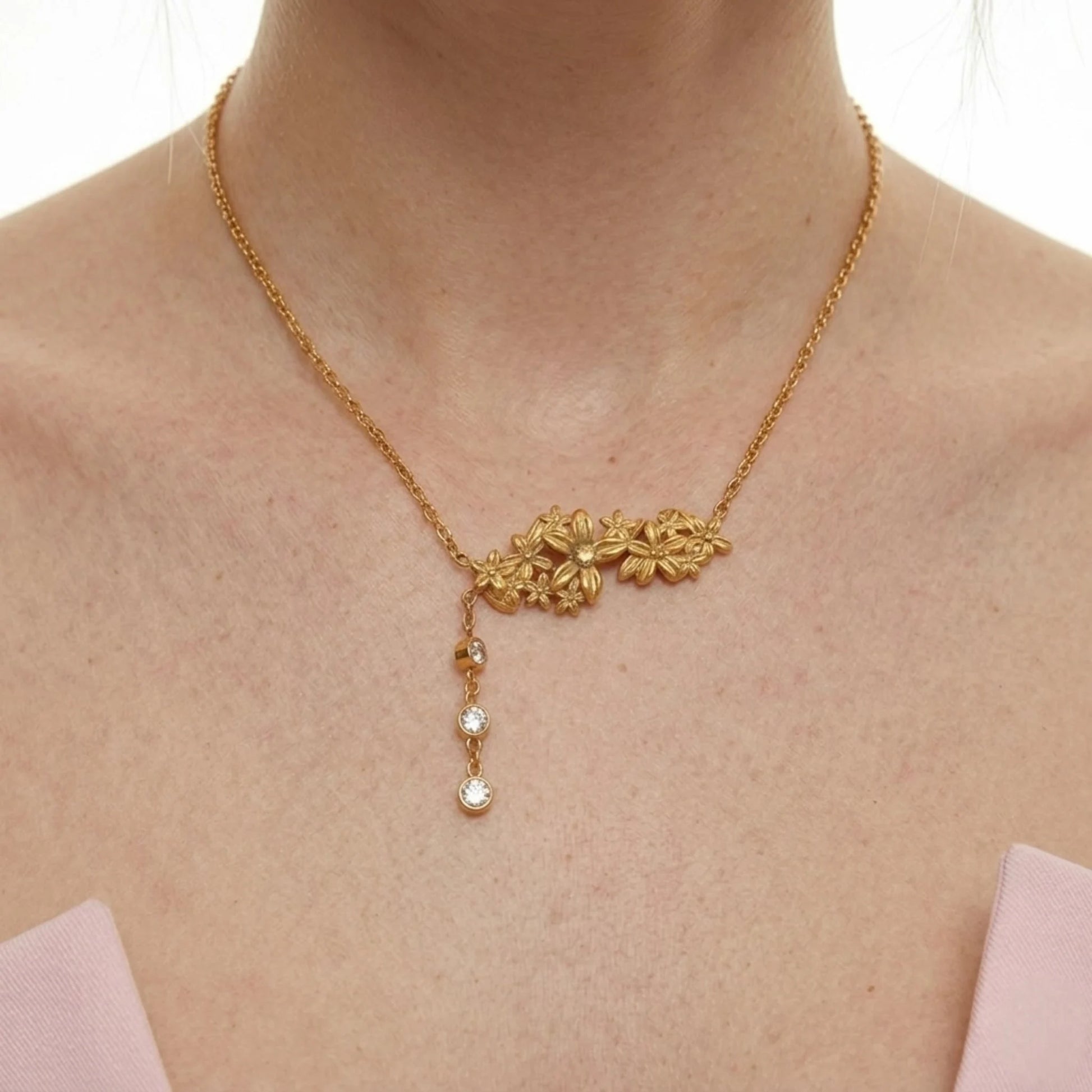 BEHI MILANO Lauris Necklace — close-up of gold floral cluster and zircon drop chain on model's collarbone