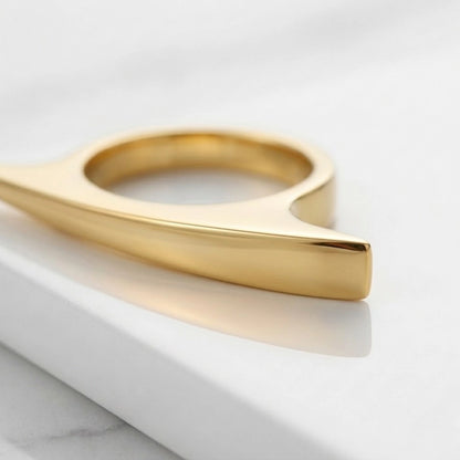 BEHI MILANO Leena Ring — gold pointed ring resting on white studio surface