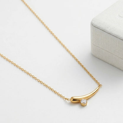 BEHI MILANO Lena Necklace — gold horn pendant necklace angled view on white surface