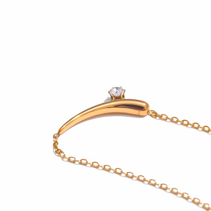 BEHI MILANO Lena Necklace — close-up of gold curved horn pendant with set zircon stone