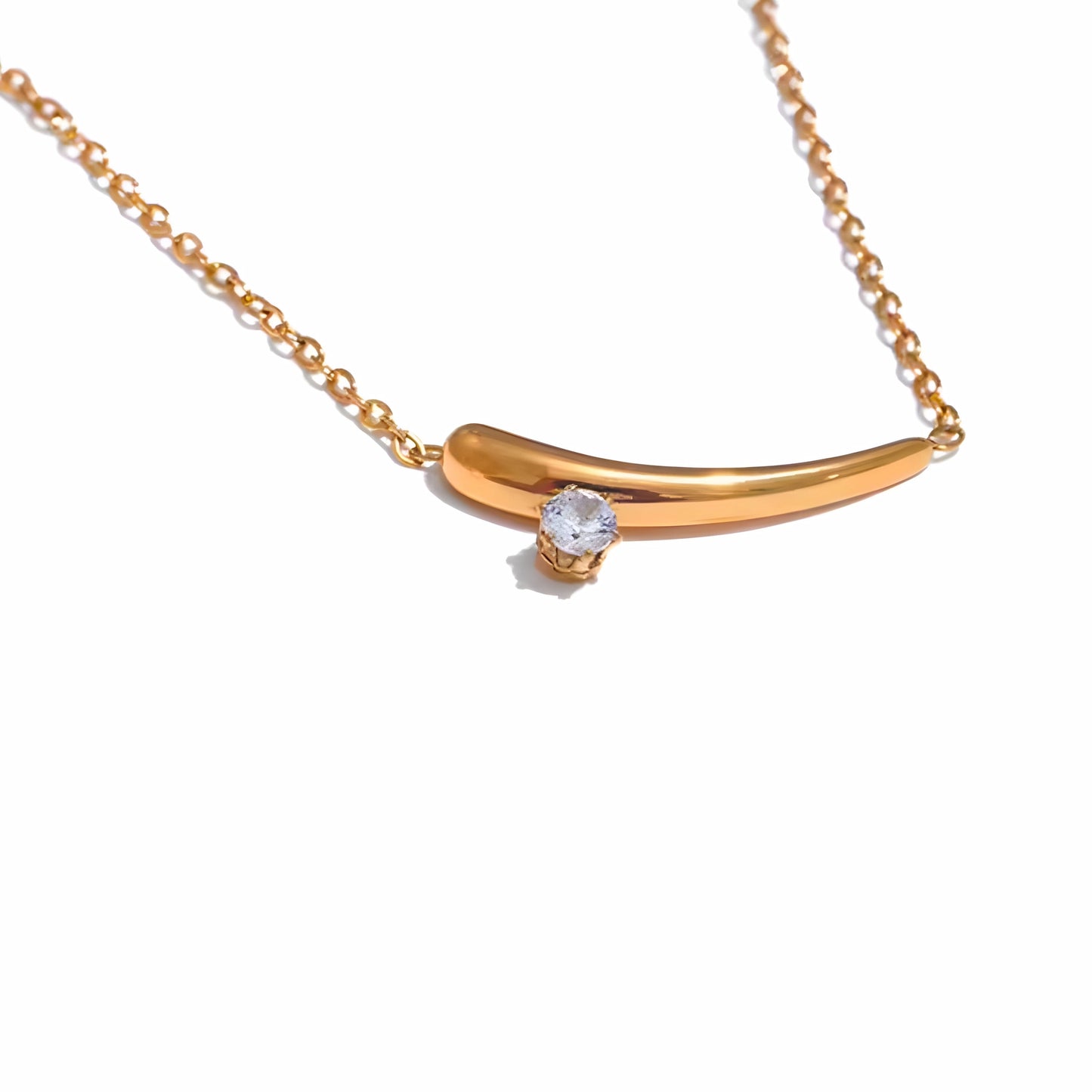 BEHI MILANO Lena Necklace — close-up of gold curved horn pendant with set zircon stone