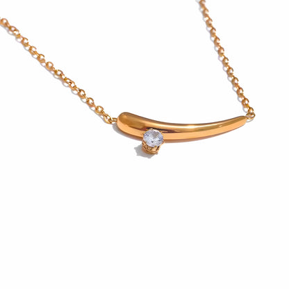 BEHI MILANO Lena Necklace — close-up of gold curved horn pendant with set zircon stone