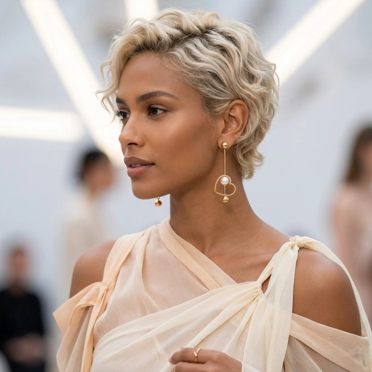BEHI MILANO Leona Earrings — model wearing gold linear heart pearl drop earrings with updo hairstyle
