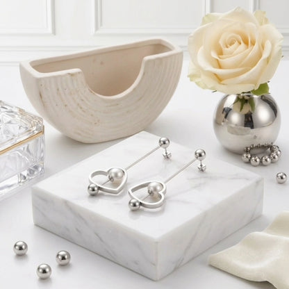 BEHI MILANO Leona Earrings — silver heart pearl drop earrings on white marble tray with roses