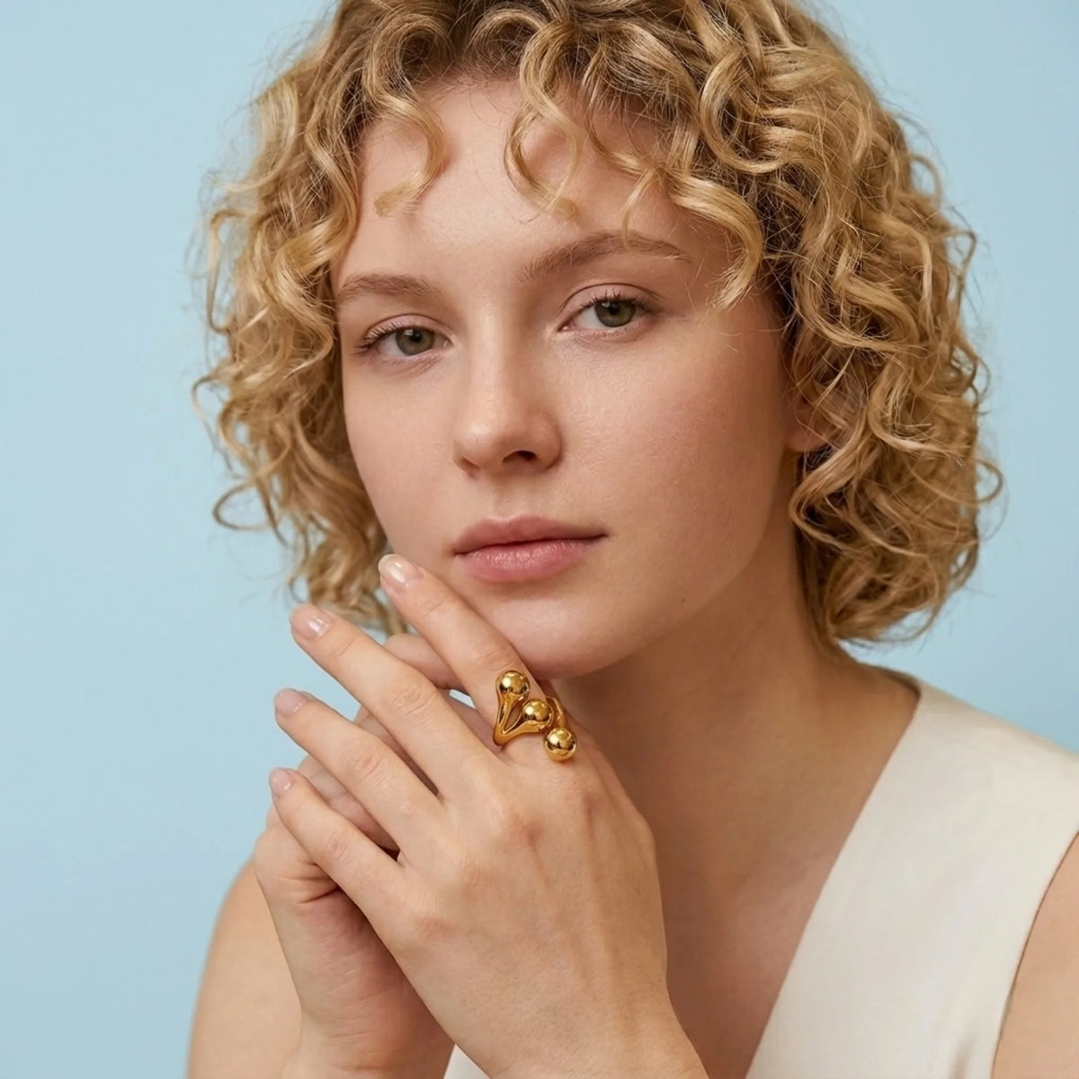 BEHI MILANO Letiz Ring — model with short curly hair wearing gold organic fluid ring