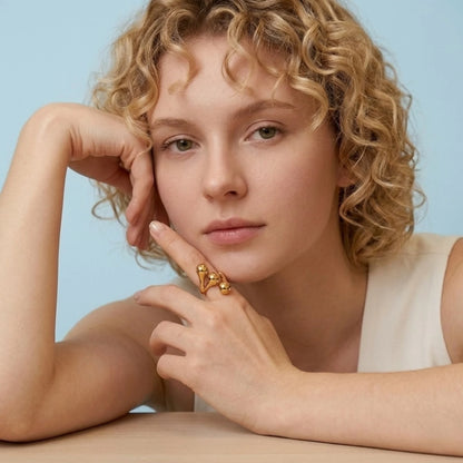 BEHI MILANO Letiz Ring — model resting chin on hand displaying gold sculptural open ring