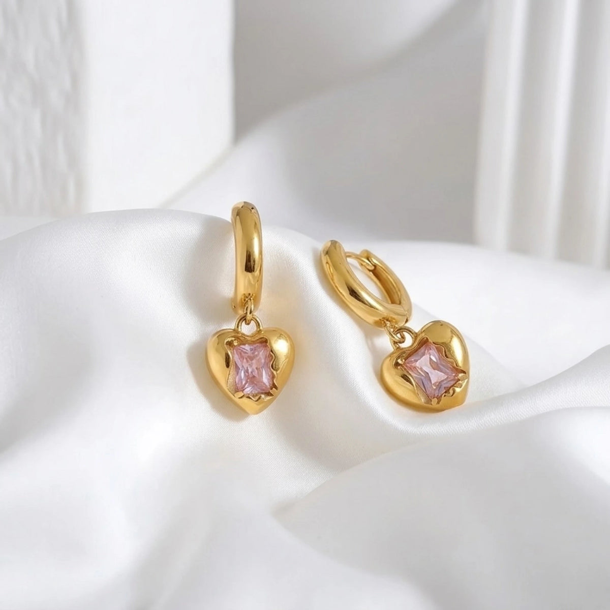 BEHI MILANO Lidia Earrings — gold heart charm hoop earrings on soft white silk fabric